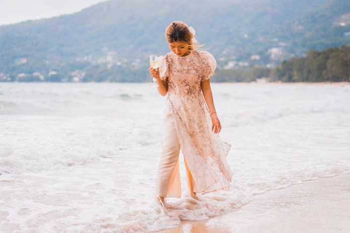 This photo shows a happy bride walking at the beach